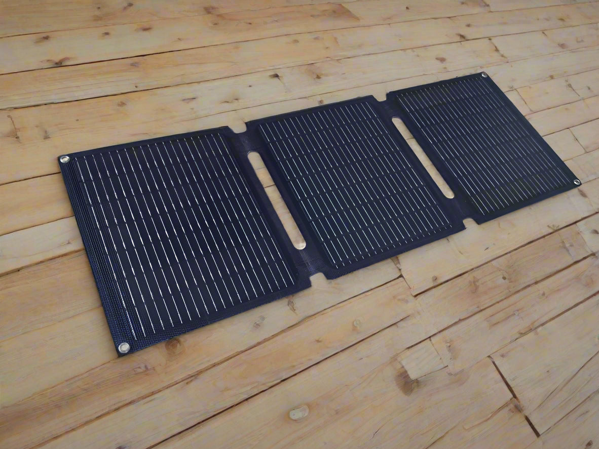 Three black solar panels charge CPAP battery power bank or phone