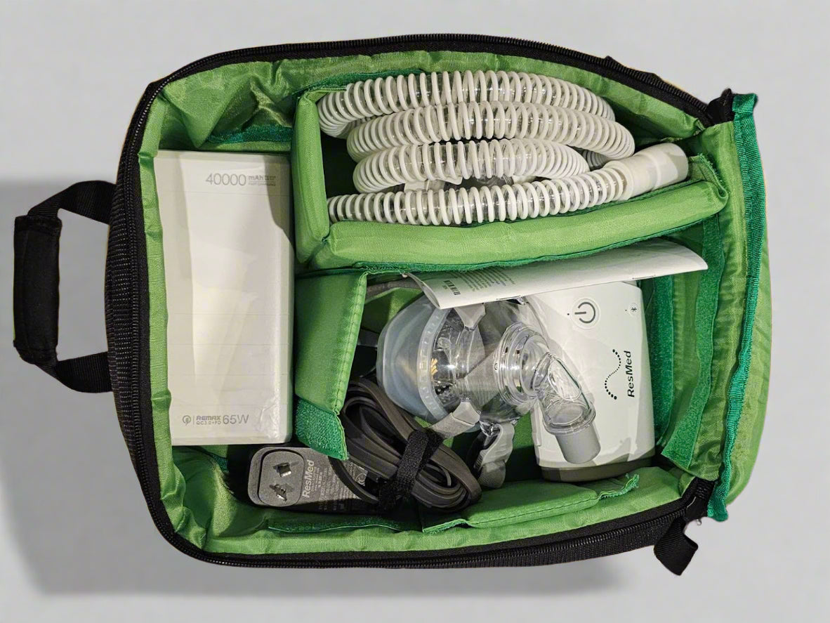 Green carrying case bag with Travel CPAP equipment including a mask and tubing and travel battery RESMED BMC 